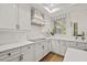 Stylish kitchen with white cabinets, modern appliances, a decorative backsplash, and hardwood floors at 1220 Darlington Oak Ne Cir, St Petersburg, FL 33703
