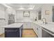 Stylish kitchen featuring white cabinets, modern appliances, a blue island, and hardwood floors at 1220 Darlington Oak Ne Cir, St Petersburg, FL 33703