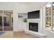 Comfortable living room featuring a fireplace, mounted TV, and seamless indoor/outdoor flow to the patio at 1220 Darlington Oak Ne Cir, St Petersburg, FL 33703