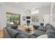 Open-concept living room with hardwood floors, a fireplace, and sliding glass doors to a screened outdoor area at 1220 Darlington Oak Ne Cir, St Petersburg, FL 33703