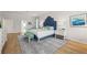 Bright and spacious main bedroom with luxury rug, wood floors, white walls, and a blue tufted headboard at 1220 Darlington Oak Ne Cir, St Petersburg, FL 33703