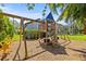 Fun wooden playset with swings, slide, and climbing area in a well-maintained backyard at 1220 Darlington Oak Ne Cir, St Petersburg, FL 33703