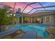 Relaxing screened-in pool area with lounge chairs and lush landscaping, perfect for outdoor entertaining and leisure at 1220 Darlington Oak Ne Cir, St Petersburg, FL 33703