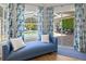 Cozy bedroom seating area with view to outdoor patio, featuring a blue lounge and coordinated blue floral curtains at 1220 Darlington Oak Ne Cir, St Petersburg, FL 33703