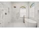 Luxurious bathroom featuring a soaking tub, rainfall shower head, and dual vanities with white marble and brass fixtures at 1220 Darlington Oak Ne Cir, St Petersburg, FL 33703