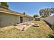 Exterior view of a backyard featuring a patio set and fire pit on a dry lawn at 12532 115Th St, Largo, FL 33778
