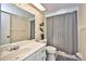 Bright bathroom features a vanity, toilet, and tub-shower combo with patterned wallpaper at 12532 115Th St, Largo, FL 33778