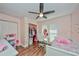 A pink bedroom with hardwood floors, a ceiling fan, and a walk-in closet at 12532 115Th St, Largo, FL 33778