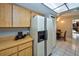Bright kitchen shows tile floor, wooden cabinets, tile countertops, appliances and a hallway to the dining room at 12532 115Th St, Largo, FL 33778