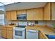 Kitchen features tile countertops, appliances including dishwasher, oven, microwave and lots of wooden cabinets at 12532 115Th St, Largo, FL 33778