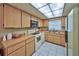 Kitchen features tile floor, wooden cabinets, tile countertops and appliances including dishwasher, oven and microwave at 12532 115Th St, Largo, FL 33778