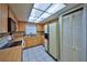 Bright kitchen has tile floor, wooden cabinets, tile countertops and appliances with view to pantry and dining at 12532 115Th St, Largo, FL 33778