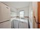 Bright laundry room featuring a washer, dryer, and a convenient shelving unit for storage solutions at 12532 115Th St, Largo, FL 33778