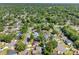 Aerial neighborhood view shows houses with pools nestled among lush trees and winding streets at 15307 Summerwind Dr, Tampa, FL 33624