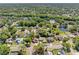 Aerial view showing a peaceful neighborhood with a tranquil pond, streets, and plentiful trees at 15307 Summerwind Dr, Tampa, FL 33624