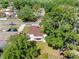 Aerial view of a home with a brown roof and a large, shady tree in a quiet neighborhood at 15307 Summerwind Dr, Tampa, FL 33624