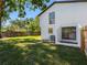 Exterior of charming home featuring a spacious backyard with lush green lawn and sunny skies at 15307 Summerwind Dr, Tampa, FL 33624