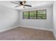 This bright bedroom features neutral walls and carpet and a large window with view of mature trees at 15307 Summerwind Dr, Tampa, FL 33624
