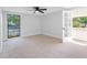 This airy bedroom features neutral walls and carpet, a large window, and a glass paneled door at 15307 Summerwind Dr, Tampa, FL 33624