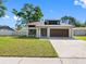Inviting home with a manicured lawn, convenient driveway and modern door, ideal for a new homeowner at 15307 Summerwind Dr, Tampa, FL 33624