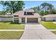 Well maintained home with a clean lawn, driveway, modern style door and a two car garage at 15307 Summerwind Dr, Tampa, FL 33624