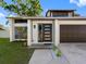 Close up of the home's front entrance with a modern door design and well maintained yard at 15307 Summerwind Dr, Tampa, FL 33624