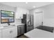 Bright kitchen with stainless steel appliances, white cabinets, and a black faucet at 15307 Summerwind Dr, Tampa, FL 33624