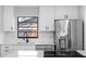 Close-up of a modern kitchen with stainless steel appliances, white cabinets, and quartz countertops at 15307 Summerwind Dr, Tampa, FL 33624