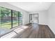 Sunlit living room featuring wood floors, large windows, and sliding glass doors to patio at 15307 Summerwind Dr, Tampa, FL 33624