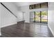 Open living room with large windows, wood-look floors, and a modern staircase at 15307 Summerwind Dr, Tampa, FL 33624
