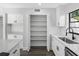 Bright kitchen featuring white cabinets, quartz countertops, and an open walk-in pantry at 15307 Summerwind Dr, Tampa, FL 33624