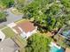Aerial view of home showcasing a brown roof, verdant lawn, refreshing pool, and mature trees at 15307 Summerwind Dr, Tampa, FL 33624