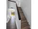 Bright home entryway featuring a wood staircase with dark handrail and wood laminate flooring at 15307 Summerwind Dr, Tampa, FL 33624