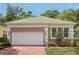 Beautiful single-story home featuring a white garage door, brick driveway and well-maintained landscaping at 15324 Sherwood Forest Dr, Tampa, FL 33647