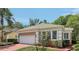 Side view of single-story home featuring a white garage door, brick driveway and well-maintained landscaping at 15324 Sherwood Forest Dr, Tampa, FL 33647