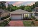 Charming single-Gathering home with a manicured lawn, brick driveway, and a two-car garage nestled in lush greenery at 15324 Sherwood Forest Dr, Tampa, FL 33647