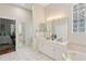 Spacious main bathroom with dual sinks, a soaking tub, and lots of natural light at 15324 Sherwood Forest Dr, Tampa, FL 33647