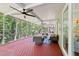 Screened in porch features an outdoor seating area with ceiling fans, wood floors and backyard view at 15324 Sherwood Forest Dr, Tampa, FL 33647