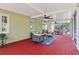 Red floored screened-in porch with furniture, fans, and outdoor atmosphere at 15324 Sherwood Forest Dr, Tampa, FL 33647