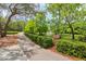 Scenic walking path with manicured landscaping and view of a pond with a fountain at 15324 Sherwood Forest Dr, Tampa, FL 33647