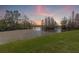 Scenic backyard view overlooking a tranquil lake at sunset at 16512 Brigadoon Dr, Tampa, FL 33618
