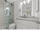 Updated bathroom featuring glass shower door, granite countertop, and modern lighting at 16512 Brigadoon Dr, Tampa, FL 33618
