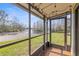 Screened porch with wood-look tiled floor overlooks lush backyard, lake, and landscaping at 16512 Brigadoon Dr, Tampa, FL 33618
