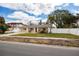 Well-kept single-story home featuring a vibrant red door, manicured lawn, and white picket fence at 1820 Massachusetts Ne Ave, St Petersburg, FL 33703