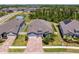 An aerial view of a landscaped single Gathering home with a brick paver driveway nestled in a community surrounded by trees at 19204 Briarbrook Dr, Tampa, FL 33647