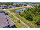 A spacious backyard with lush green grass, a pond, and a white picket fence offers privacy and natural beauty at 19204 Briarbrook Dr, Tampa, FL 33647
