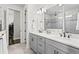 Modern bathroom featuring a double vanity, marble countertop, and a glass-enclosed shower at 19204 Briarbrook Dr, Tampa, FL 33647