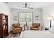 Bright bedroom showcasing two comfy chairs, a wooden bookcase, and a large window view at 19204 Briarbrook Dr, Tampa, FL 33647