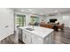 Open-concept kitchen with an island and stainless dishwasher overlooking the adjacent living room with modern finishes at 19204 Briarbrook Dr, Tampa, FL 33647