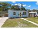 Charming light blue house with a bright yellow front door and a well-maintained lawn at 1974 N Betty Ln, Clearwater, FL 33755